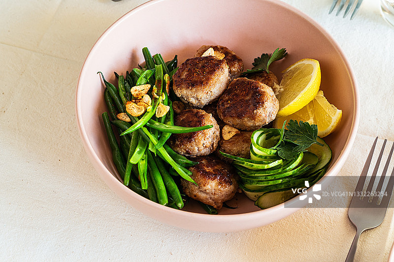 猪肉丸配炒青豆和黄瓜沙拉图片素材