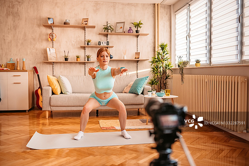 在镜头前为她的视频博客锻炼的女人图片素材