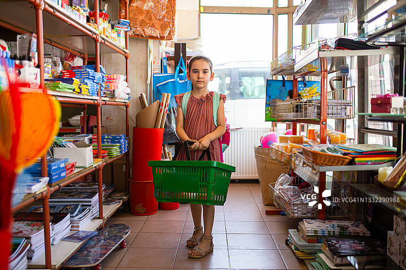 独立的学龄前女孩在商店里自己购买必需的学校用品图片素材