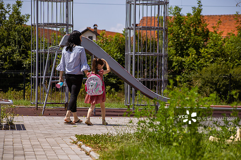 放学后，快乐的女学生牵着妈妈的手图片素材