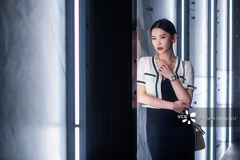 年轻的中国女人站在白色霓虹灯旁图片素材