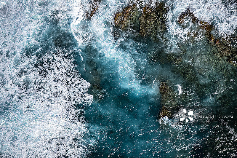 蓝色海浪拍打岩石的鸟瞰图图片素材