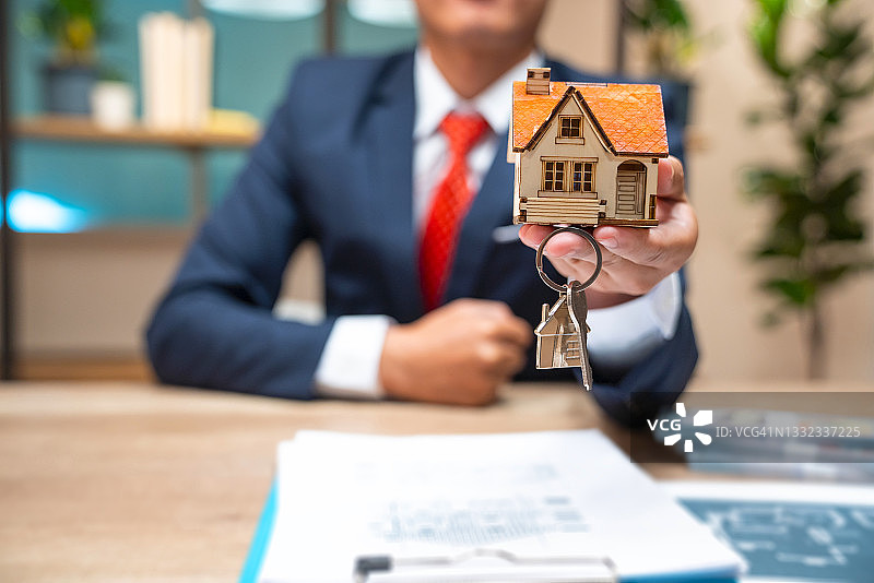 房地产经纪人在办公室与客户签约后交房钥匙图片素材