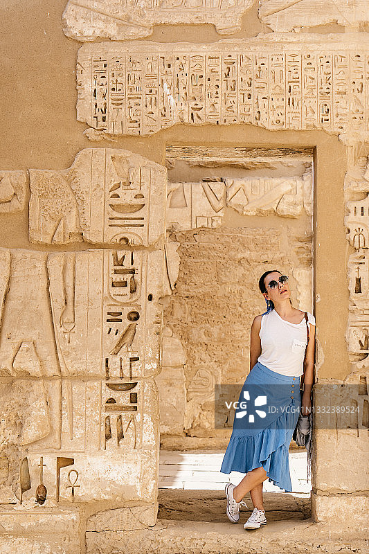 时尚女游客在石砌建筑中欣赏历史建筑图片素材