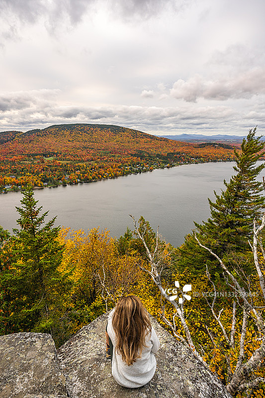 秋季，女人观赏湖泊和森林图片素材