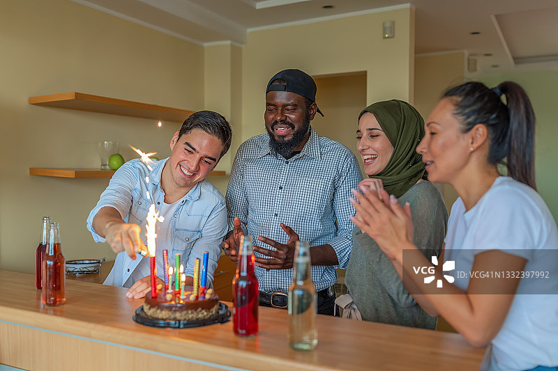 年轻男人和不同种族的朋友庆祝生日图片素材