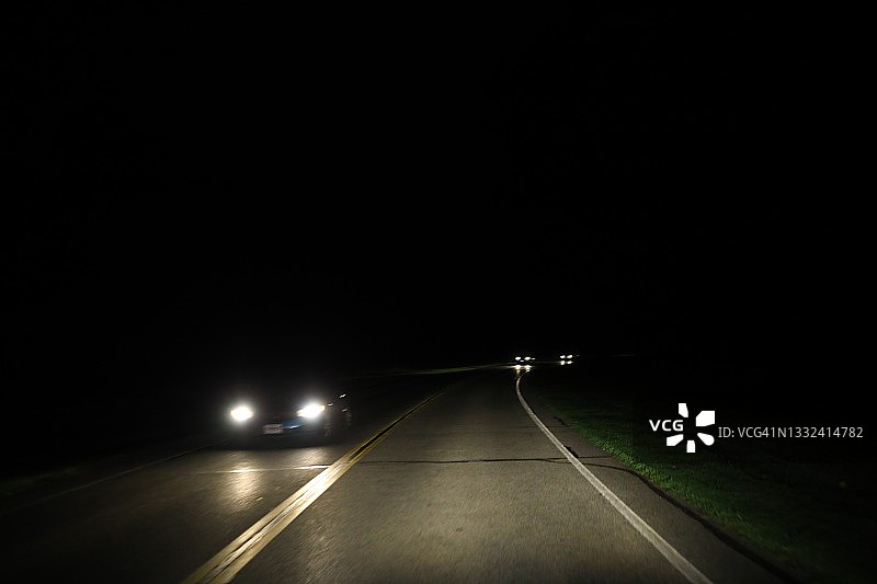 行驶中汽车的逼近大灯图片素材