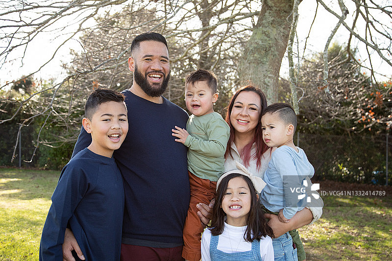 公园里的家庭照 - 其中一个孩子患有唐氏综合症图片素材