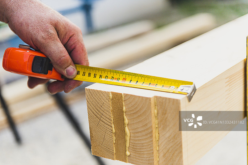 木匠在木制屋顶梁上标记尺寸图片素材