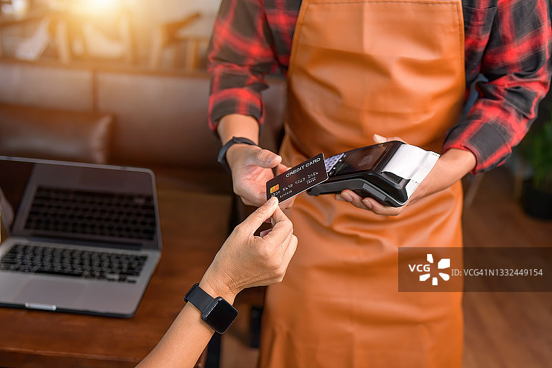 女人在信用卡读卡器上进行非接触式支付图片素材