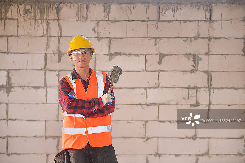 站在建筑工地墙前的瓦工肖像图片素材