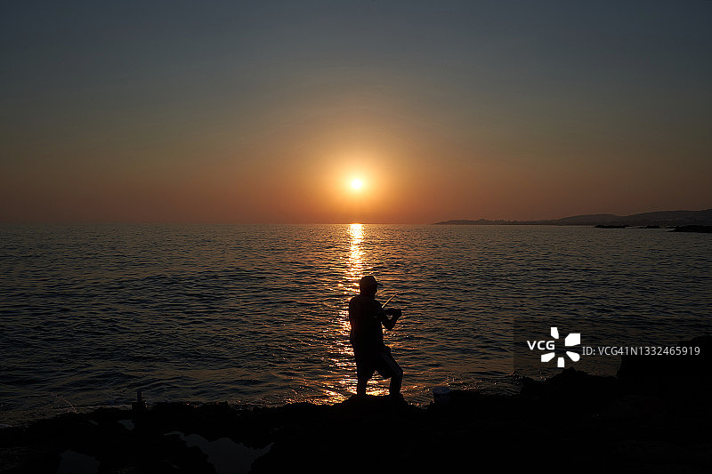 夕阳背景下的渔民图片素材