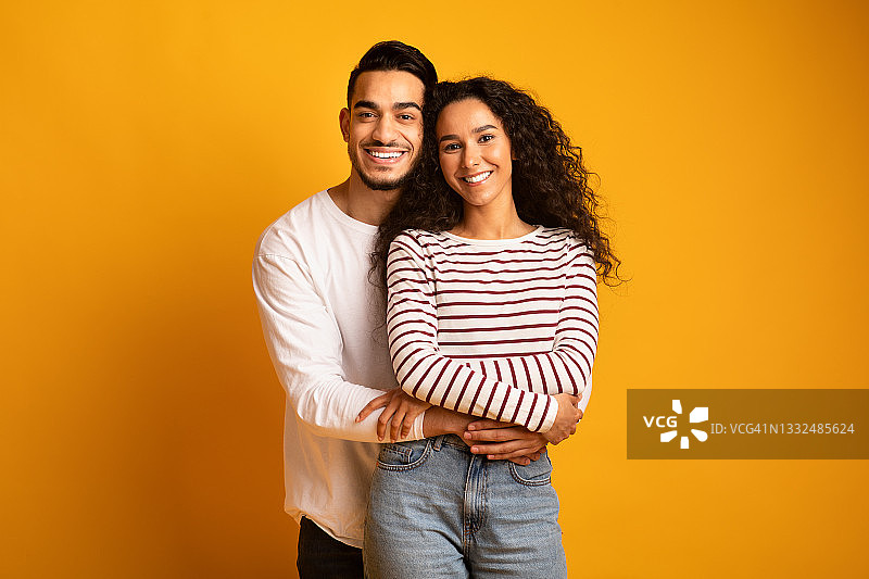 拥抱微笑的快乐阿拉伯年轻夫妇肖像图片素材