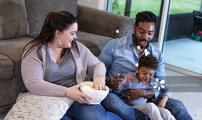 多民族家庭看电视，扔爆米花图片素材