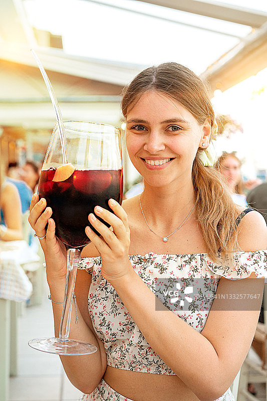 手持桑格利亚鸡尾酒的美丽女人肖像图片素材