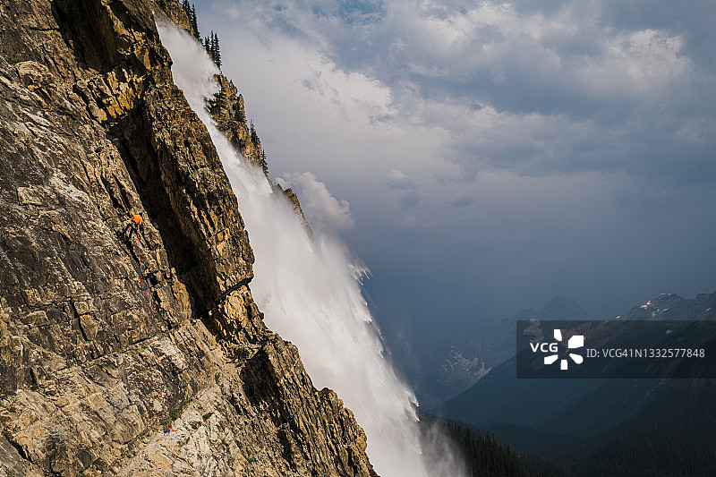 攀岩者在幽鹤国家公园壮观的瀑布旁绳降图片素材