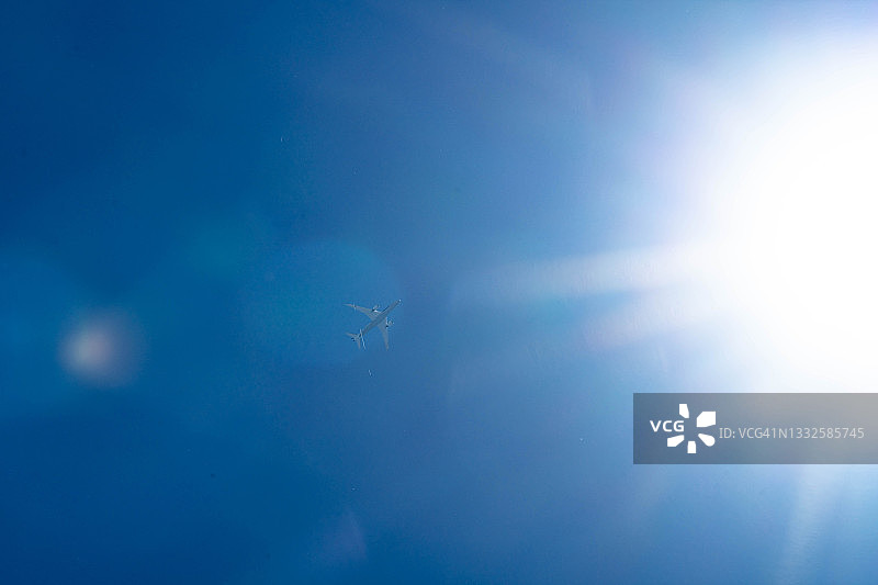 阳光下飞越日本神奈川县上空的飞机图片素材