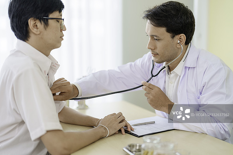 医生在医院通过听诊器检查男性患者的心率图片素材