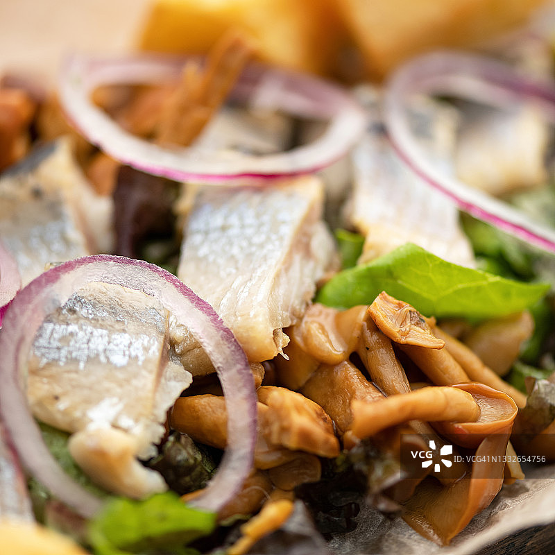 咸味开胃菜：洋葱腌鲱鱼和腌蘑菇，特写镜头，柔焦图片素材