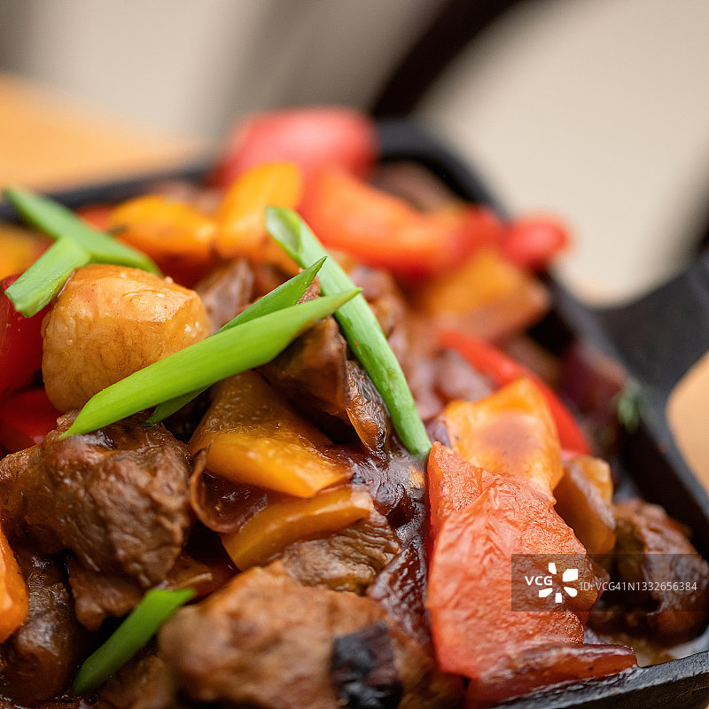 铸铁锅中炖牛肉和蔬菜特写。健康的乡村食物。柔焦。复制空间图片素材
