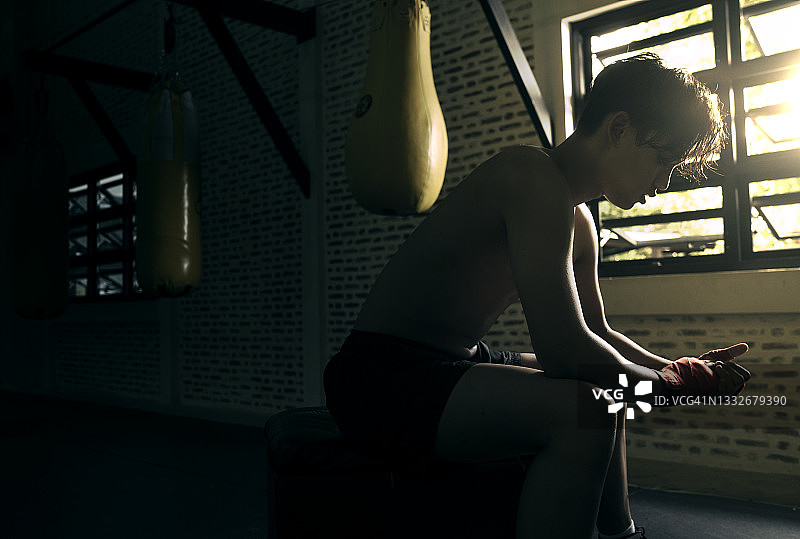 年轻拳击手在拳击比赛失败后感到消极情绪和悲伤的广角照片图片素材