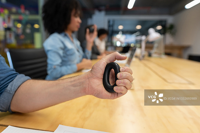 在办公室里捏手环减压的商人图片素材