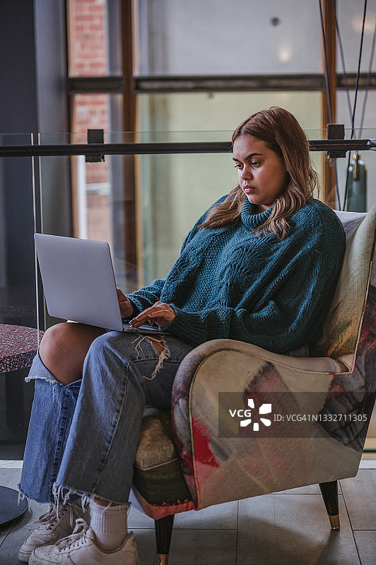 年轻女人用笔记本电脑工作时的沉思时刻图片素材