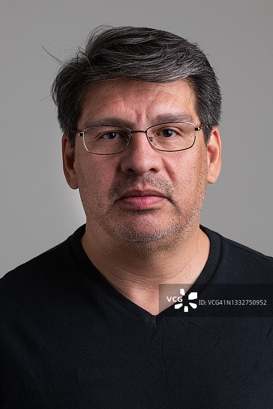 灰色背景下看着镜头的成熟男人图片素材