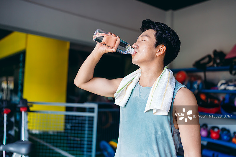 在健身房训练后喝水的健壮男人，健康和健身理念图片素材