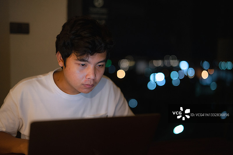 在黑暗中工作的自由职业男子图片素材