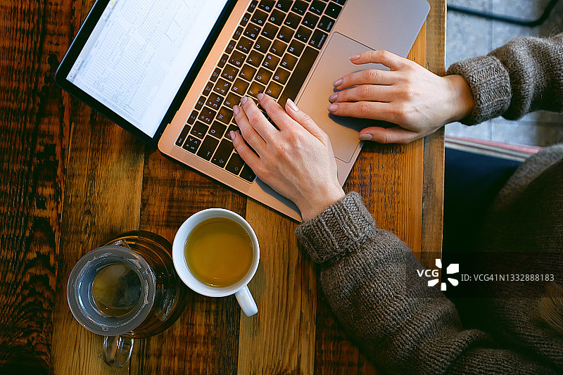 女人在咖啡馆或共享空间用电脑键盘打字图片素材