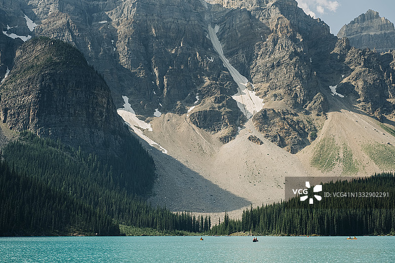 独木舟划过大型山脉下的梦莲湖图片素材