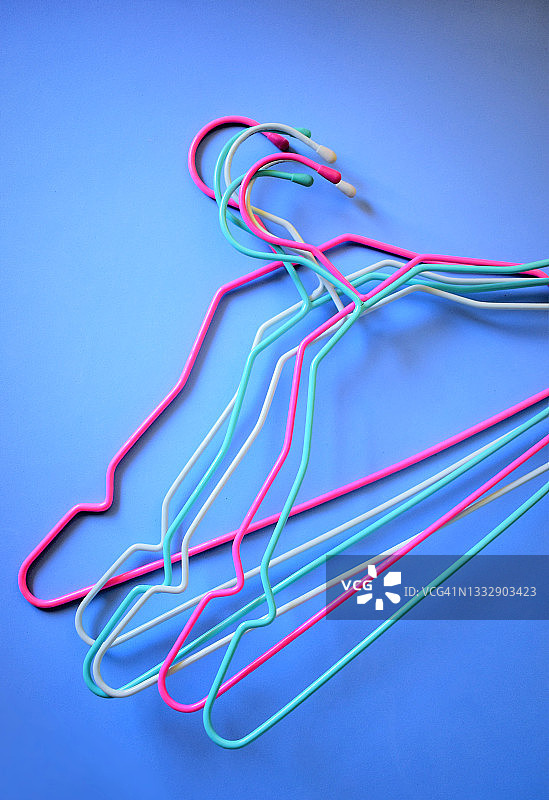 蓝色背景上的彩色衣架图片素材