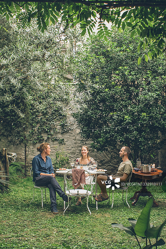朋友们在葱郁的后院享受夏日午餐图片素材