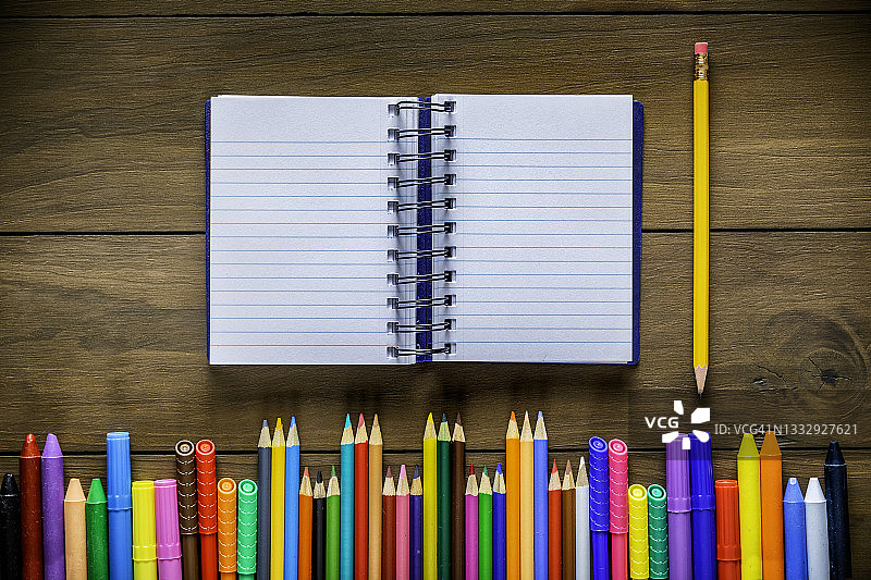木桌上彩色铅笔记号笔与笔记本俯视图图片素材