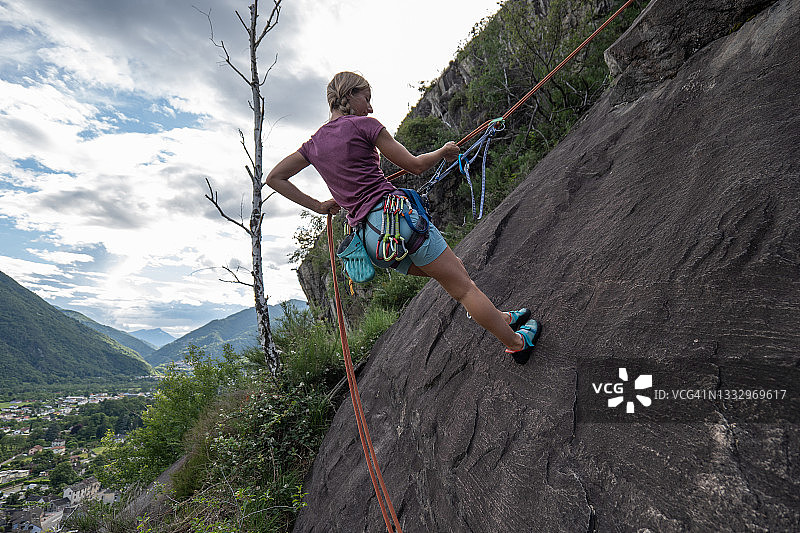 在石板上绳降的登山女性图片素材