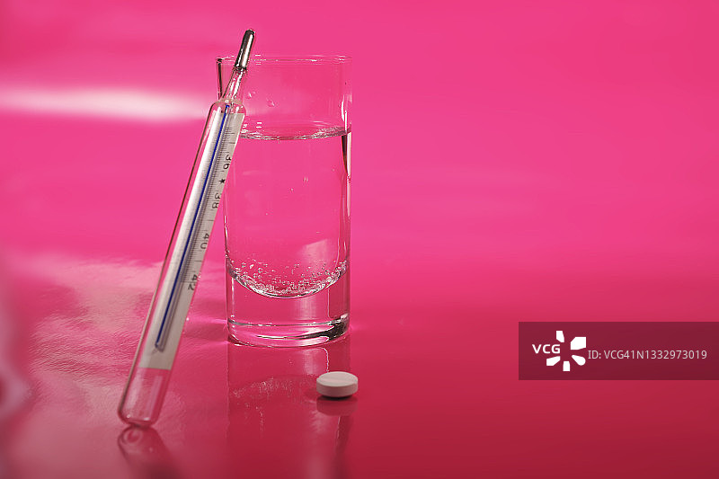 体温计、一杯水和药丸图片素材