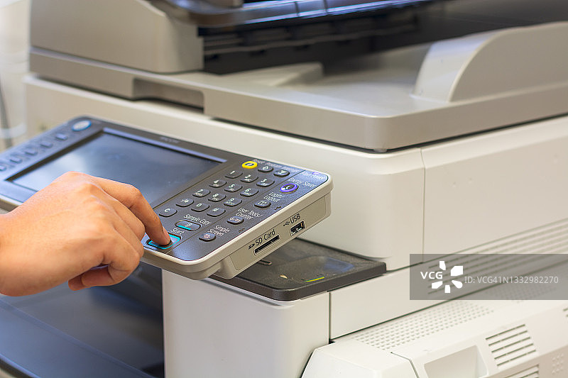 特写：办公室人员按下复印机面板上的复印按钮，在复印室扫描文件并进行复印图片素材