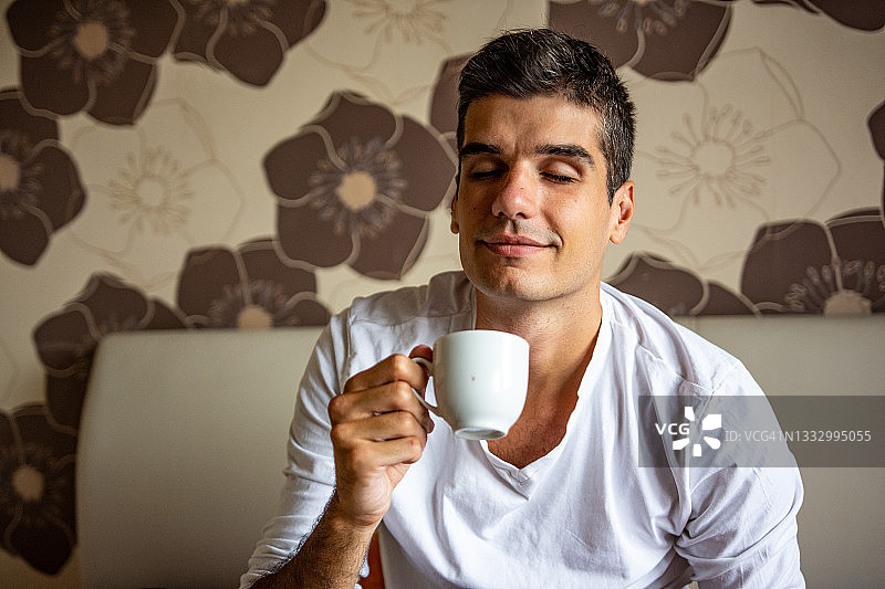 青年男子在床上喝咖啡图片素材