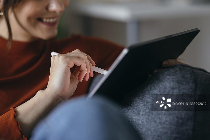 在家使用平板电脑的年轻女士图片素材