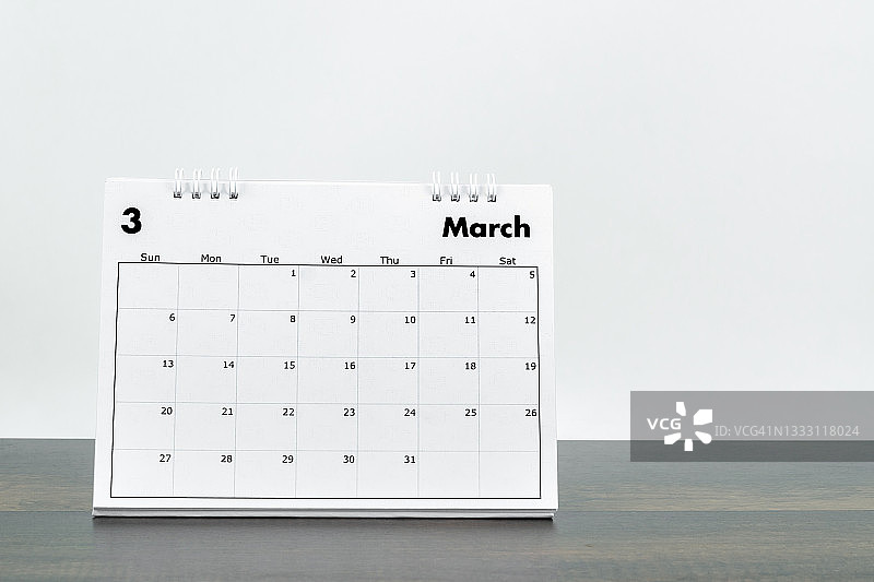 2022年3月桌面日历，用于计划和提醒，背景为白色复古水泥墙木桌。图片素材