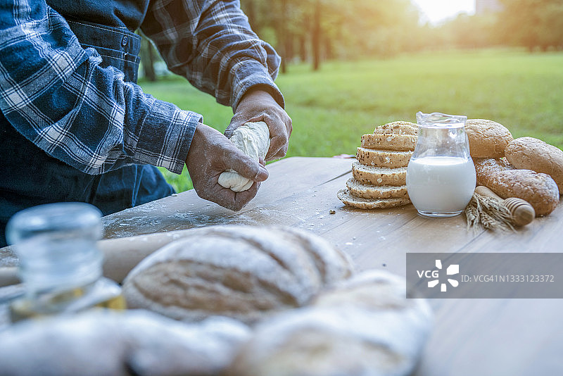 双手在桌子上揉生面团，平铺拍摄图片素材