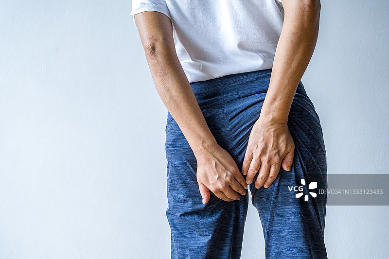 感到疼痛，正在按压臀部的女人图片素材