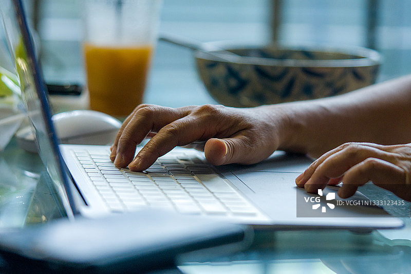 女人在家工作时用笔记本电脑打字图片素材