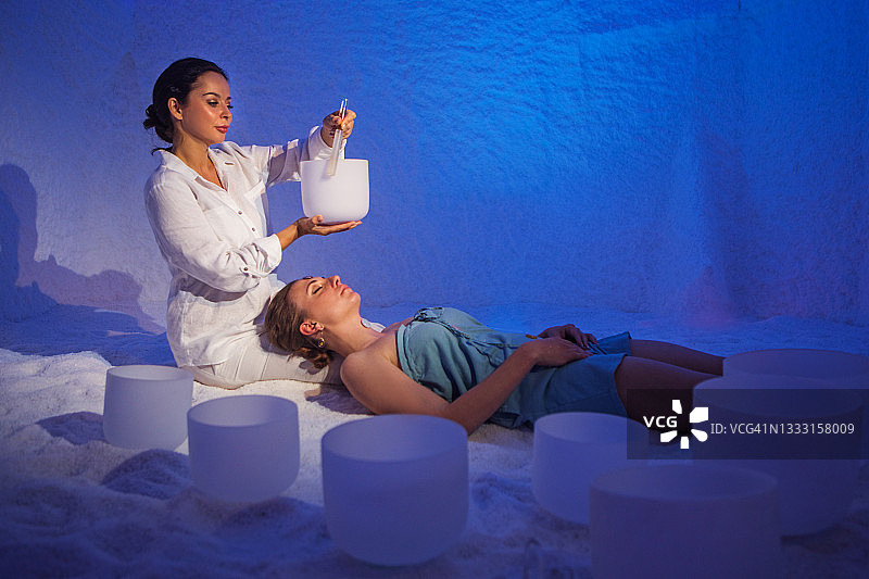 在健康水疗盐洞中为个人进行声音疗愈仪式图片素材