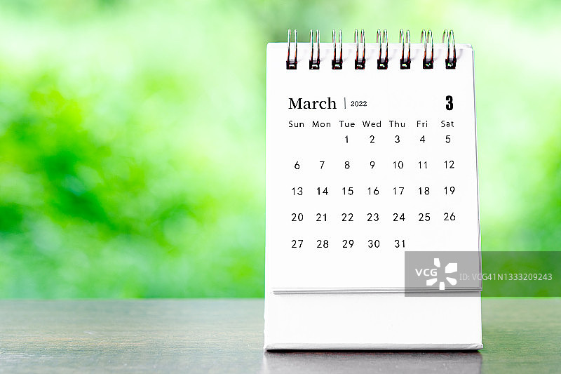 2022年3月桌面日历，用于在木桌上规划和提醒。图片素材
