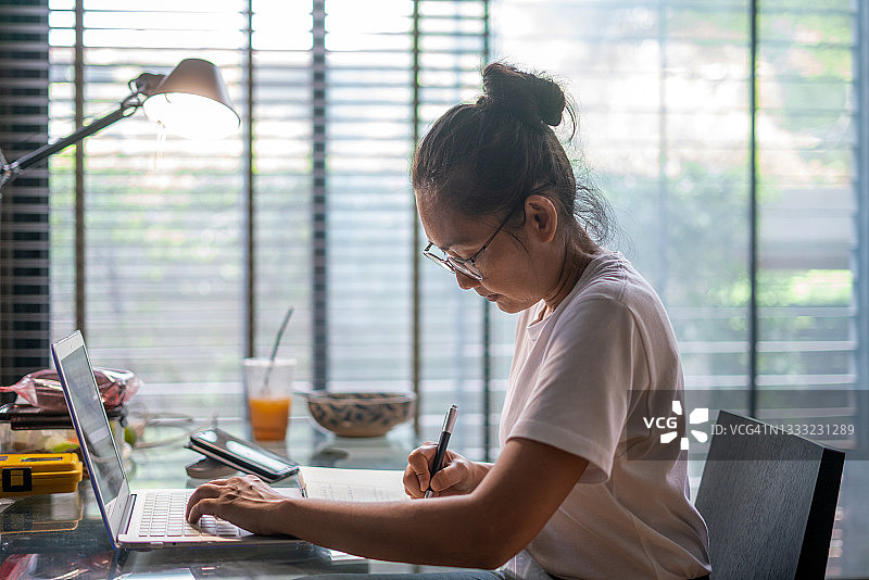 年轻快乐的商务女性在办公室里使用笔记本电脑图片素材