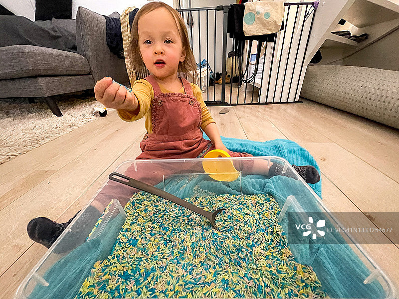 孩子玩耍着彩色米粒图片素材