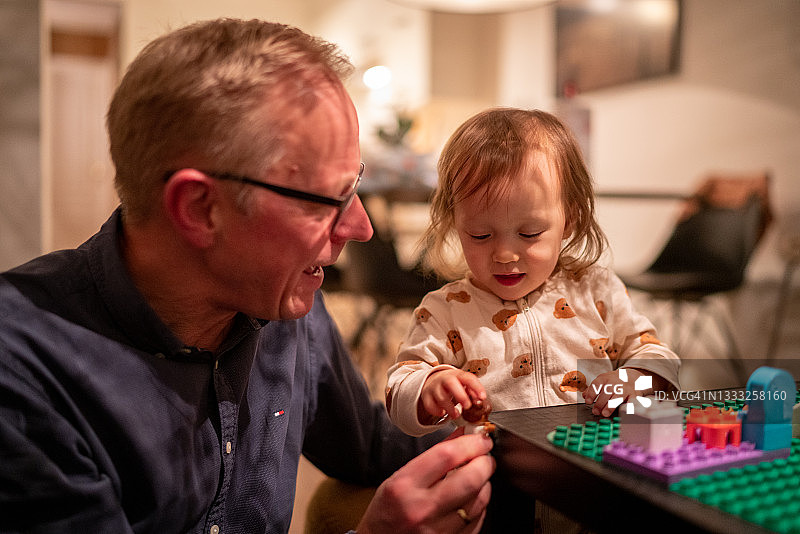 一个女婴向外公展示她的积木技巧图片素材