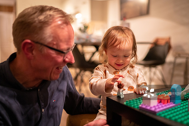 一个女婴向外公展示她的积木技巧图片素材